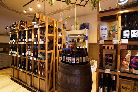 Weinregale mit Flaschen und Holzfässern im Ladengeschäft in Berlin-Friedrichshagen
