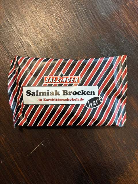 Zartbitter Salmiak Lakritz Brocken von Salzinger, 100g, mit dunkler Schokoladenüberzug und salzigem Salmiak-Geschmack.