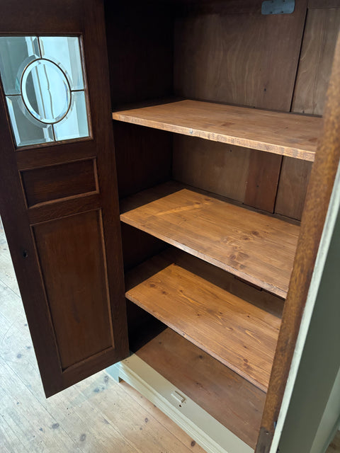 Zweitürige antike Vitrine in Kreidefarbe Gooseberry, grün-grau, mit dekorativen Holzdetails und Glasfenstern.