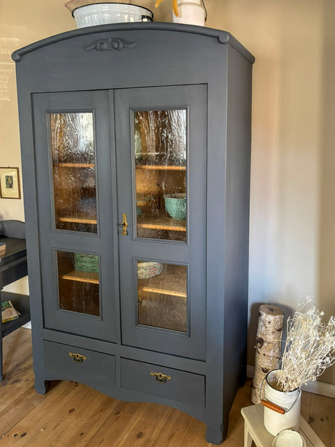 Zweitürige antike Weichholz-Vitrine in Kreidefarbe Smoke, grau-blau, mit eleganten Holzdetails und vintage Design.
