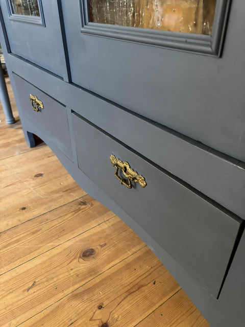 Zweitürige antike Weichholzvitrine in Kreidefarbe Smoke, grau-blau, mit eleganten Holzdetails und antikem Charme.