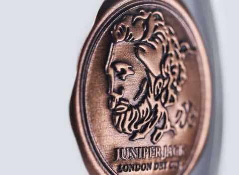 Drei Flaschen Juniper Jack Gin im Set von Independent Spirits Dresden, mit grünem Etikett und stilvollem Design.