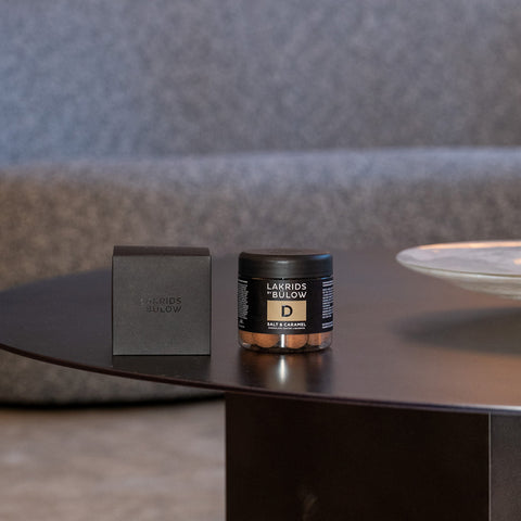 Lakrids by Bülow Lakritz mit gesalzenem Karamell in 115g Packung, close-up Ansicht der schwarzen Lakritzstücke mit Karamellfüllung