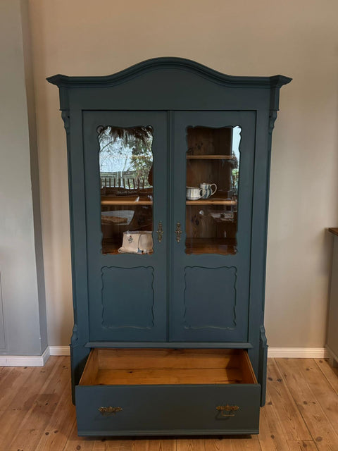 Zweitürige antike Weichholz Vitrine in Kreidefarbe Baronesse, blau, mit klassischem Design und sichtbaren Holzdetails.