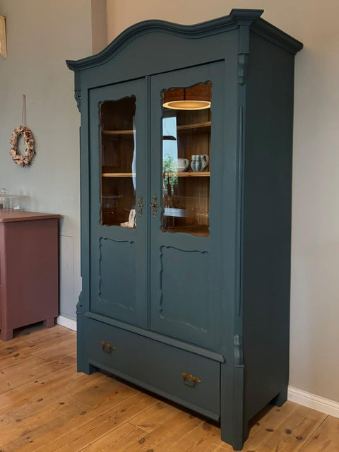 Zweitürige antike Weichholzvitrine in Kreidefarbe Baronesse Blau von Weingärtners Genusshandwerk, mit sichtbaren Türen und Details.
